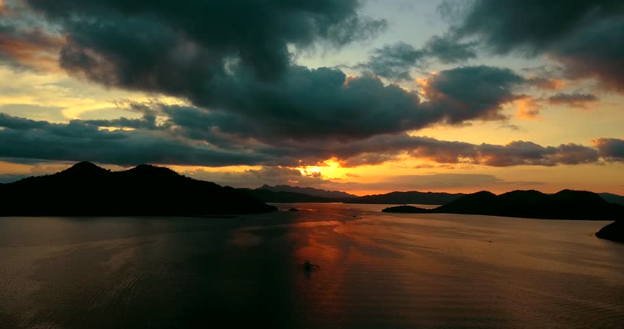 Ascend into clouds during dramatic sunset over sea. Coron Bay, Palawan, Philippines. Royalty-Free Stock Footage #1027112309