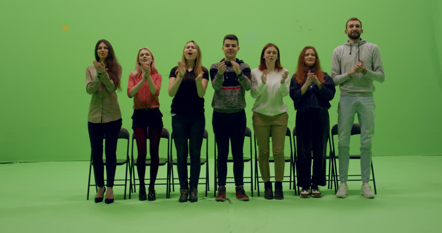 GREEN SCREEN CHROMA KEY Front view group of young people applause and rise to their feet while looking at smth behind the camera. 4K UHD ProRes 4444