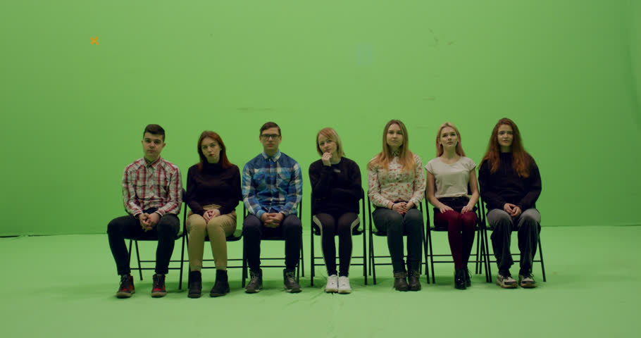 GREEN SCREEN CHROMA KEY Front view group of young people sitting, applause and looking at smth behind the camera. 4K UHD ProRes 4444