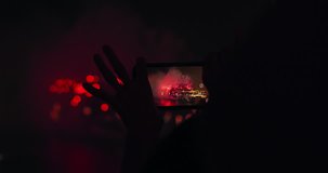 People using smartphones to capture video Hong kong national day fireworks 2018. Red cinema camera hand held, slow motion. Note: Silhouette people, No recognizable faces. 