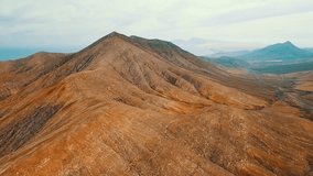 Landscape view on mountains brown, bronze background in summer sunny day with blue sky, Drone 4K Video
