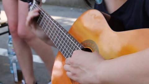 Girl performer on street playing guitar