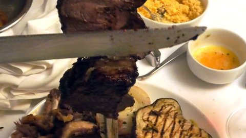Close up of a picanha beef cutting. Set table blurred in Brazilian steak house. วิดีโอสต็อก
