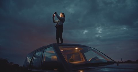 Young woman taking panoramic photo on smartphone device or catches signal on her mobile phone searching interesting places in mountains, slow motion, shot on cine camera 4K