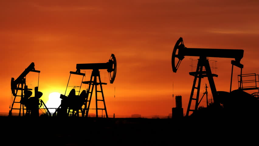 working oil pumps silhouette against timelapse sunrise