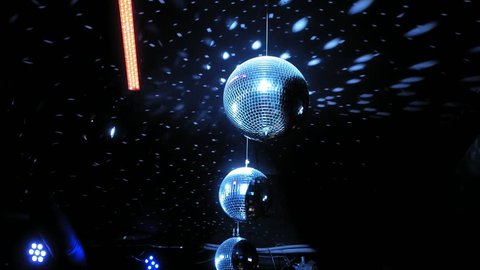 spinning disco mirror ball in a dark room, blue light