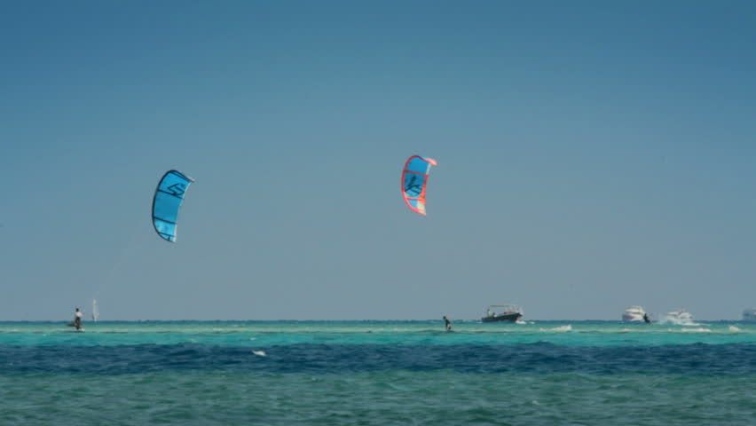 kite surfing - surfers on blue sea surface
