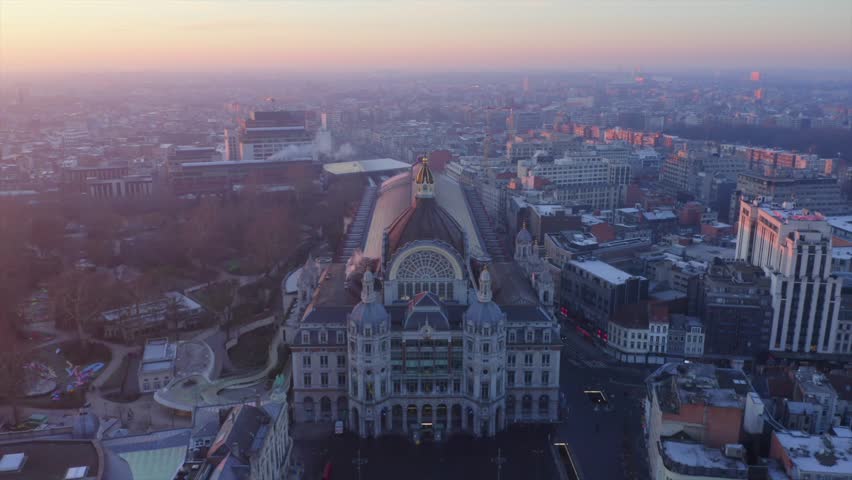 Video shows the beautiful train station in Antwerp with sunrise background. The sky orange sky turn the station into golden color. The station is the most beautiful station in world.