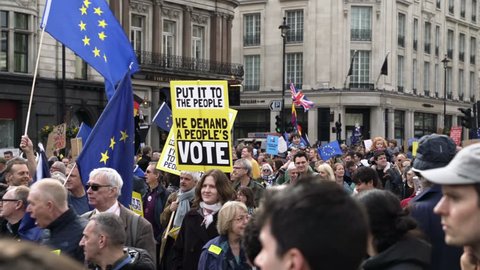 LONDON, UK - MARCH 23 2019: Thousands of pro EU protesters against Brexit at The Peoples Vote demonstration walks with placards and European Union flags