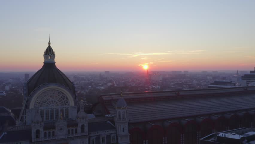 Video shows the beautiful train station in Antwerp with sunrise background. The sky orange sky turn the station into golden color. The station is the most beautiful station in world.