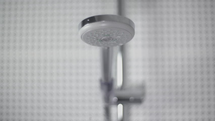Close-up of turning on and off shower head in bathroom, white tiles with black pattern on the walls, water flow in front of camera, falling drops in slow motion | Shutterstock HD Video #1027184165