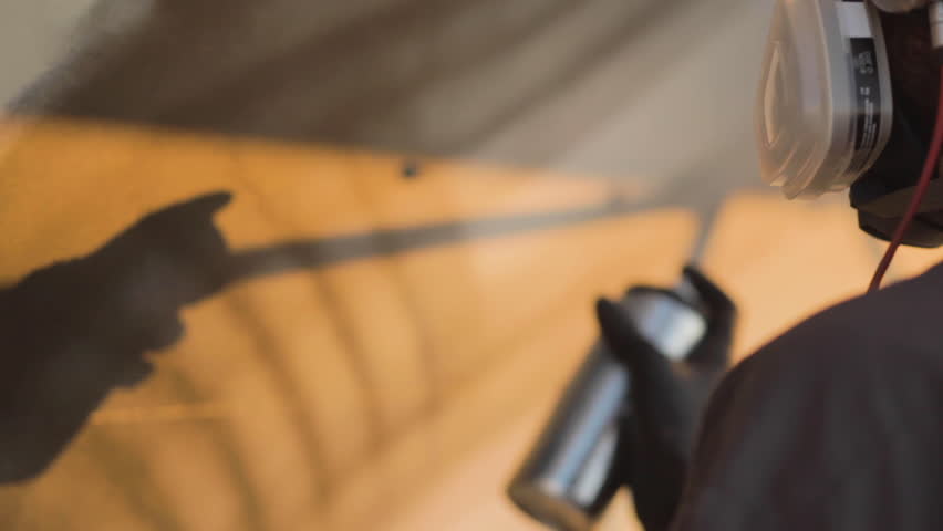 Graffiti artist spray painting a wall.