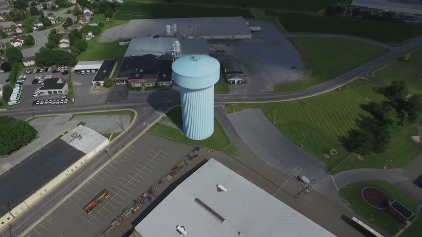 Aerial shot - Drone flying over large watertower standing in industrial area. Shot in New Holland, Pennsylvania.
