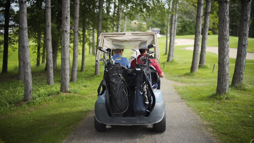 Golf cart driving through a beautiful golf course in slow motion.