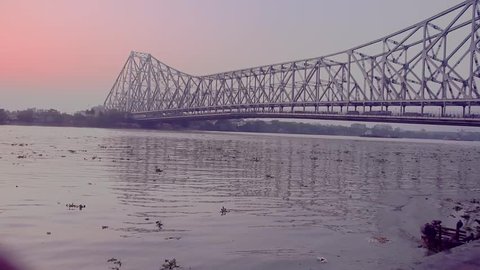 Howrah Bridge and water flow in river Ganges at sunset time in Kolkata city