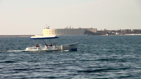 Sevastopol, Russia, October 8, 2014. Pleasure boat floats on Sevastopol Bay. View of city and battery of Constantine on opposite shore of bay. Calm and serene life after 2014 referendum.
