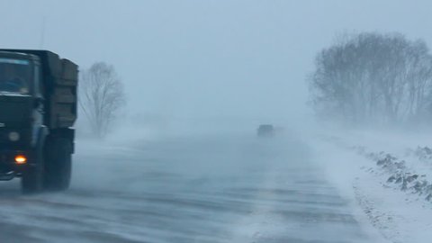 cars on winter road during blizzard