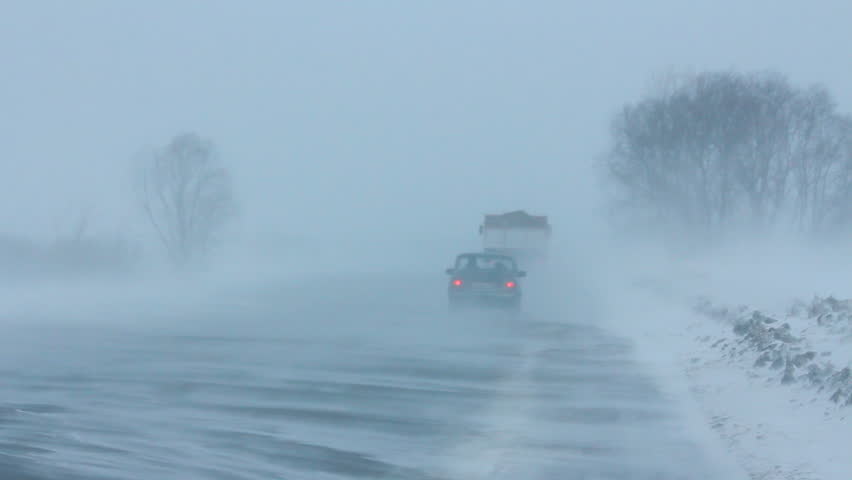 cars on winter road during blizzard
