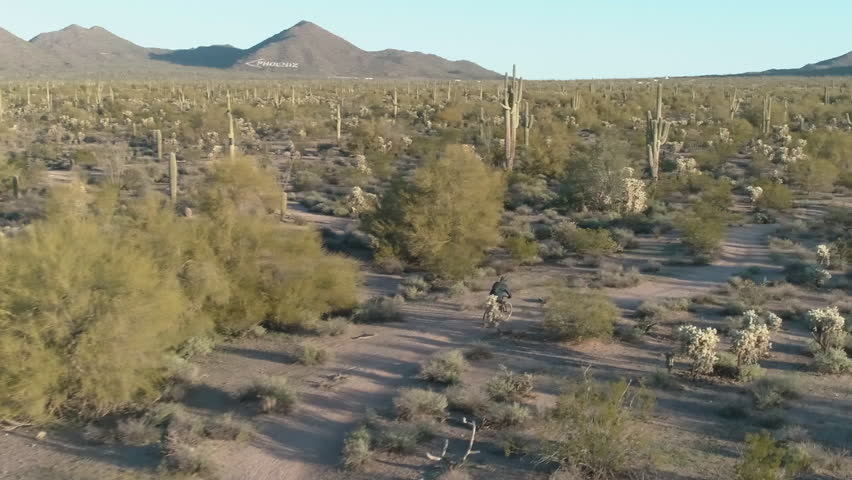 Aerial View of Mountain Biker Riding Through Arid Desert Landscape in Phoenix