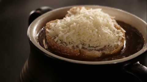 A time lapse of French onion soup topped wiuth bread and cheese toasting in the oven