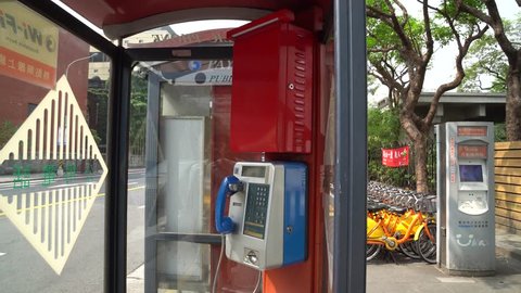 TAIPEI, TAIWAN - MAY 19, 2018: Public telephone booth on sidewalk front of Taipei main station Taipei, Taiwan.