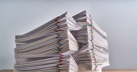 Pile overload paperwork of report of sale and receipt with colorful paperclip place on wood table and white background with copy space time lapse. Business and finance concepts successful footage.