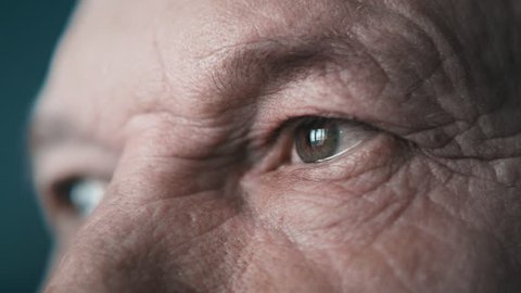 Close-up portrait of an old man. Eyes of an elderly man close-up in profile. A grown man looks away. Cool color, slow motion. 4K