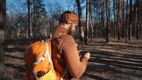 theme tourism hiking forest and technology. Man Caucasian male beard traveler uses hand phone make photo video with backpack active outdoor travel lifestyle adventure concept active leisure forest.