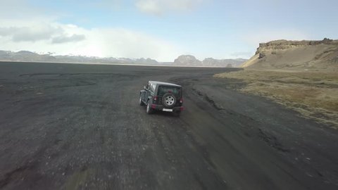 VIK, ICELAND - MAY 03, 2018: Jeep Wrangler Unlimited four wheel drive vehicle driving on black sand terrain in Iceland, on a volcanic outwash plain at Hjorleifshofdi