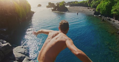 POV shot of young adventurous man cliff jumping into sunny blue pool in the jungle, POV adventure lifestyle