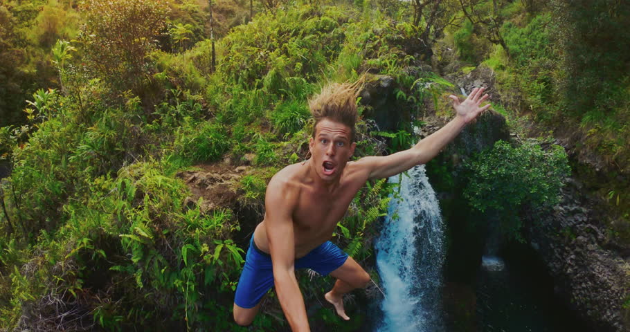 POV shot of young adventurous man cliff jumping off of amazing jungle waterfall, tropical vacation lifestyle Royalty-Free Stock Footage #1027259219