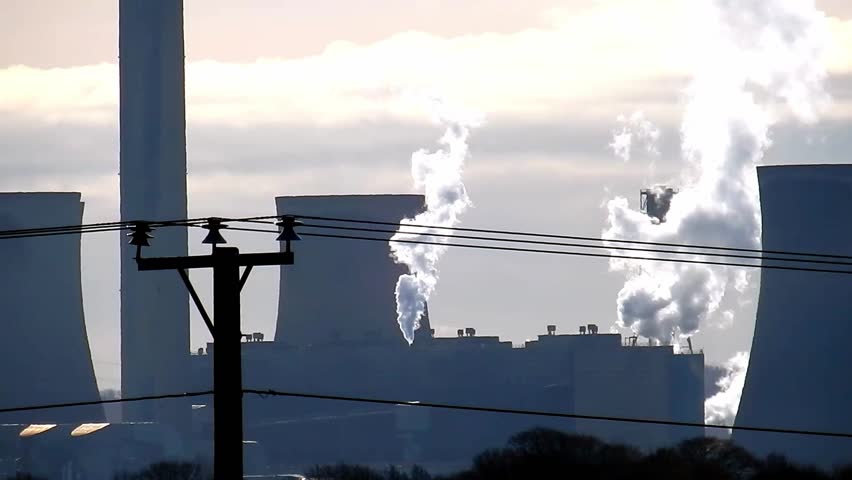 Close up view of silhouette chimney stack & industrial plant processing. Vapour smoke from buildings chimneys.