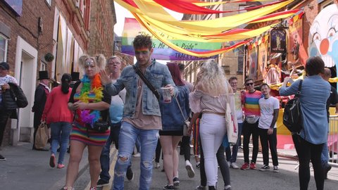 Dancing guy at LGBTQ, Lesbian, Gay, Bisexual, Transgendered, Queer, Pride Parade Street Party Celebration with Rainbow flags in slow motion Full Body