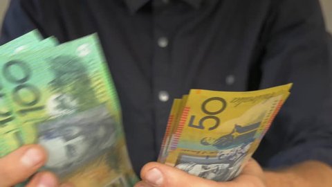 Close up of male hands counting Australian money