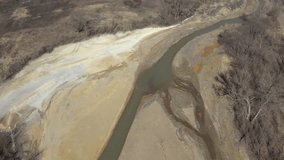 Pyrite on river coast from mine drainage 4K aerial video