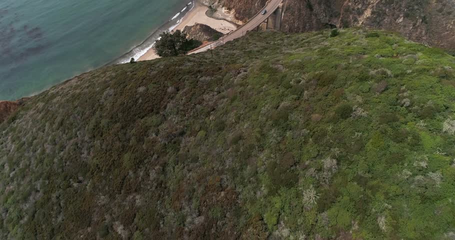 Aerial Drone Stock Video of Bixby Bridge Highway with water and shore below in Big Sur Monterrey California