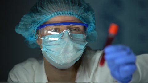 Medical lab worker analyzing blood serum, conducting paternity blood test, DNA