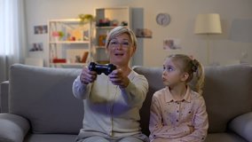 Upset granddaughter taking game joystick from granny hands, misunderstanding