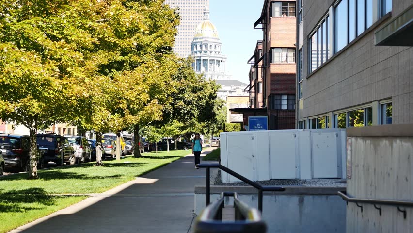 Teenager walks down the street in Capitol Hill Denver talking on her cellphone