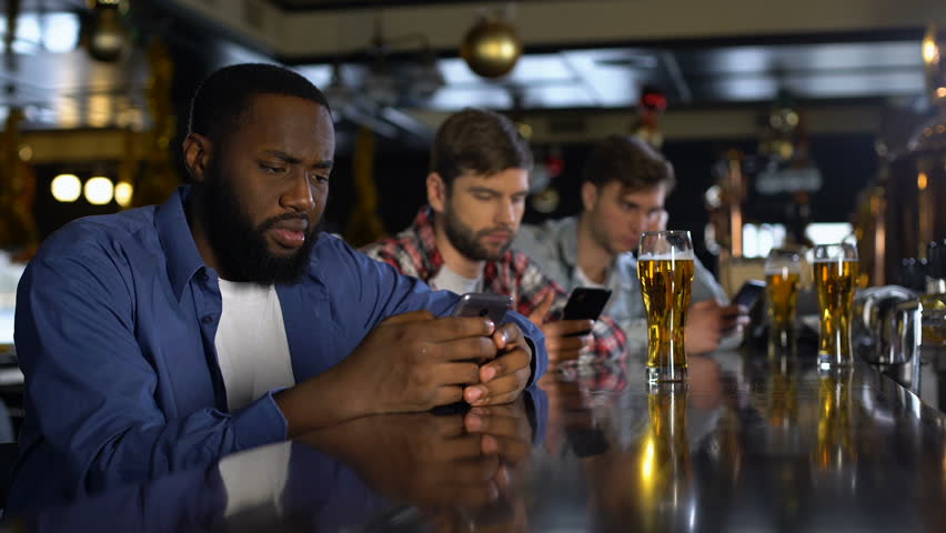 Upset men using cellphones in bar, bored alone on weekends, gadget addiction Royalty-Free Stock Footage #1027297175
