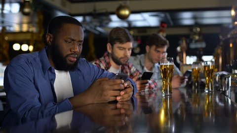 Upset men using cellphones in bar, bored alone on weekends, gadget addiction