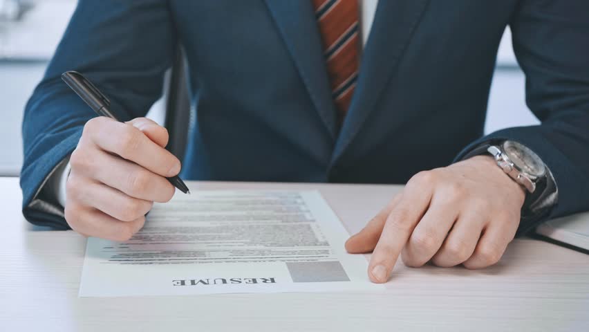 cropped view of man filling and signing document with resume lettering in office Royalty-Free Stock Footage #1027299608