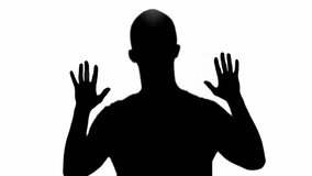 silhouette of man showing palms and slowly gesturing isolated on white
