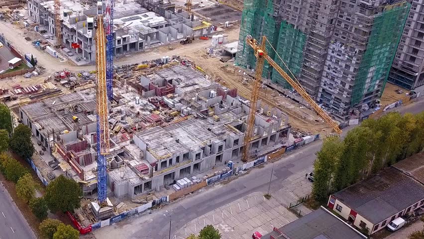 Construction of a residential building. Cranes and constuction site. Drone footage. Simple flyby shot. Gdansk, Poland.