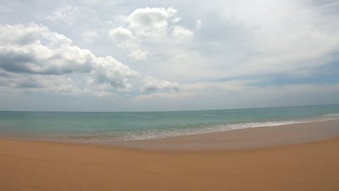 Mai Khao beach with cloudy blue sky and waves at Phuket Seascape, Thailand. Beautiful island on the Andaman coast.