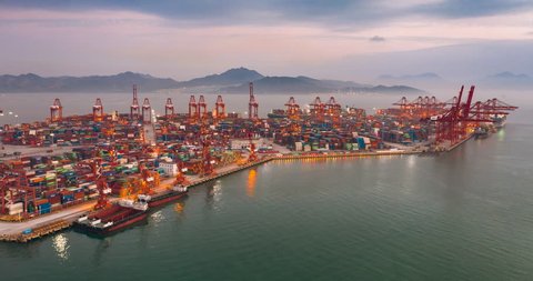 Time lapse aerial view of cargo terminal in Shenzhen,China. containers and cranes in the dock.The freight terminal is colorful in twilight.