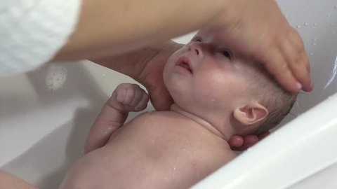 Mother take a bath for his newborn baby. Baby bath time
