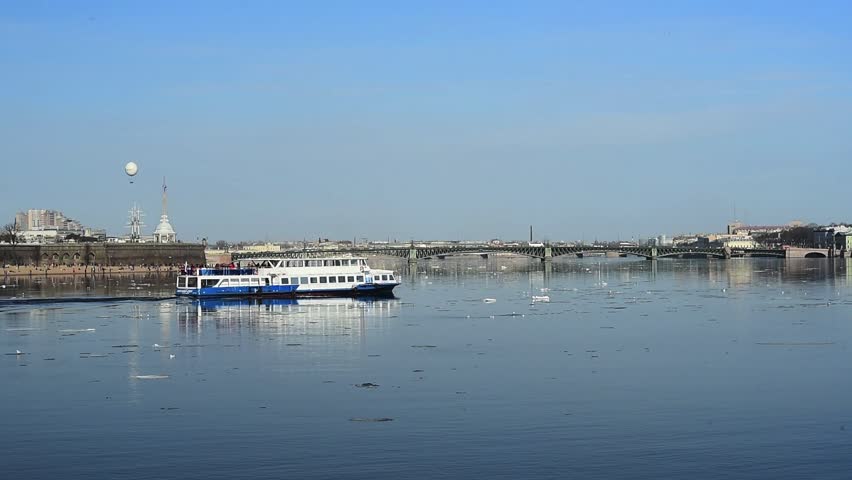 River tourist ship moves along on spring water of the Neva River between ice floes, St. Petersburg, Russia
