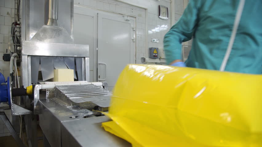 Cheese packaging process. Close up of cheese processing at food factory. Cheese factory manufacturing process.