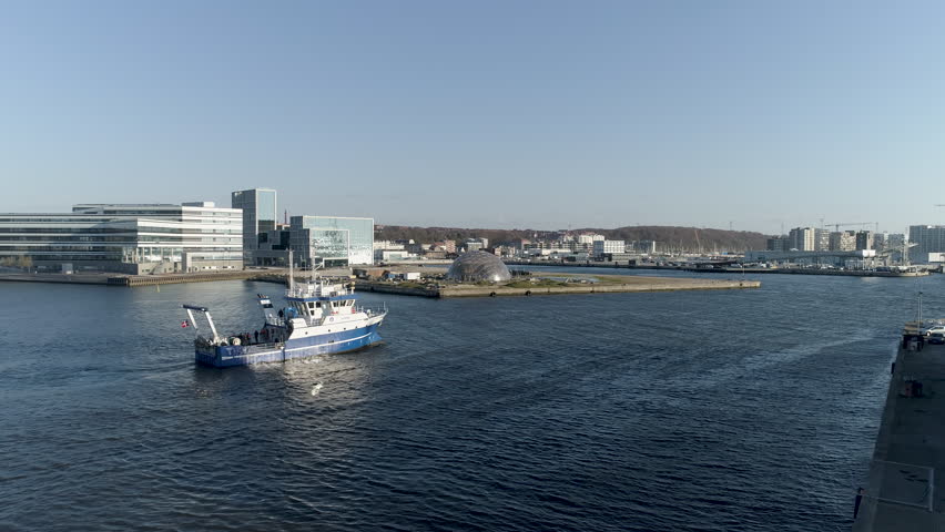 Aerial view of fishing boat leaving city port in Aarhus denmark